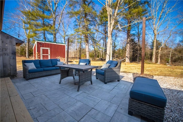 view of patio featuring an outdoor hangout area, a shed, and an outbuilding