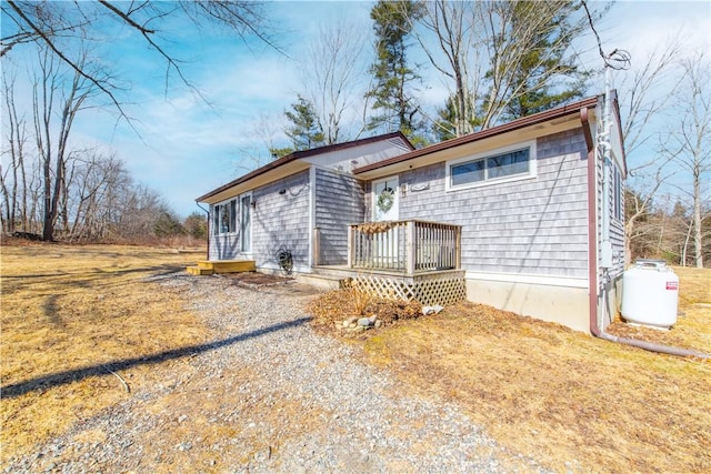 ranch-style home with a front lawn and a wooden deck