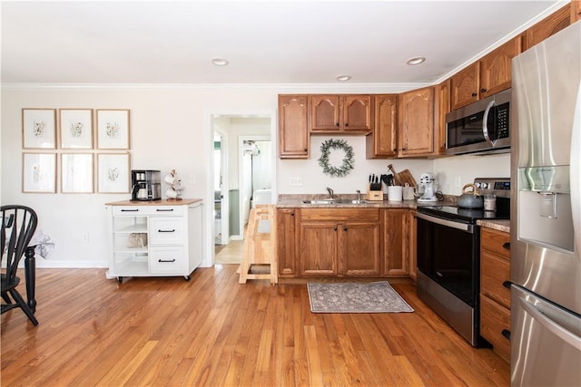 kitchen with stainless steel appliances, brown cabinetry, and light wood-style floors