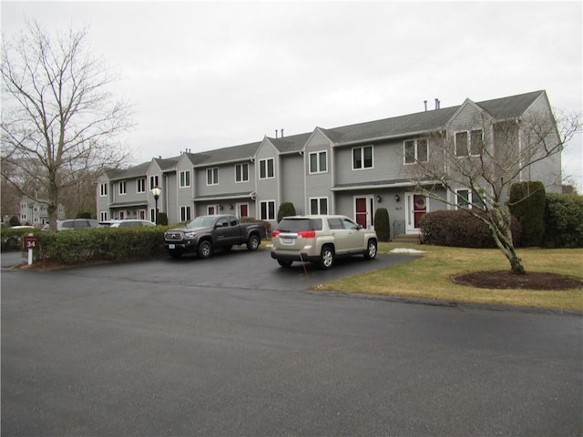 view of property featuring a residential view and a front lawn