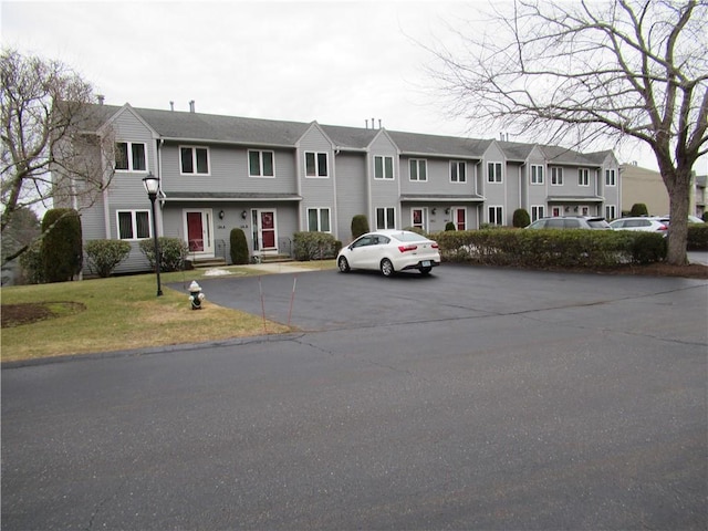 townhome / multi-family property with a residential view, uncovered parking, and a front yard