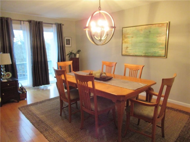 dining room with a chandelier, baseboards, and wood finished floors