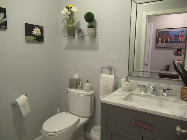 bathroom featuring vanity, toilet, and baseboards