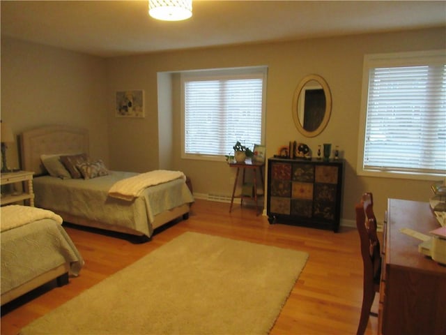 bedroom with baseboards and light wood finished floors