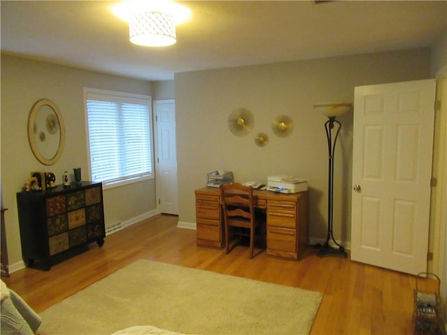 office area with light wood-style floors and baseboards