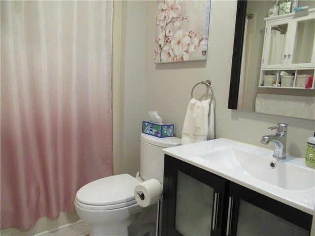 full bathroom with a shower with shower curtain, vanity, and toilet