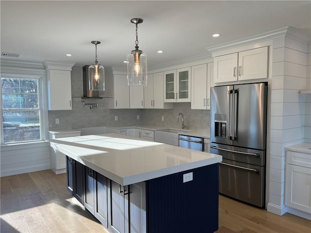 kitchen featuring a sink, light countertops, wood finished floors, and stainless steel appliances