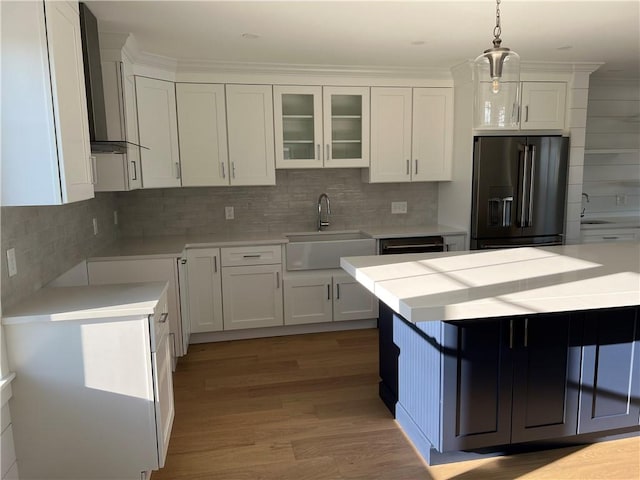 kitchen featuring tasteful backsplash, glass insert cabinets, white cabinets, black appliances, and a sink