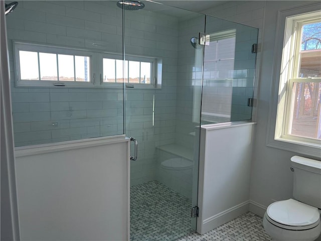 full bath with a shower stall, toilet, and baseboards