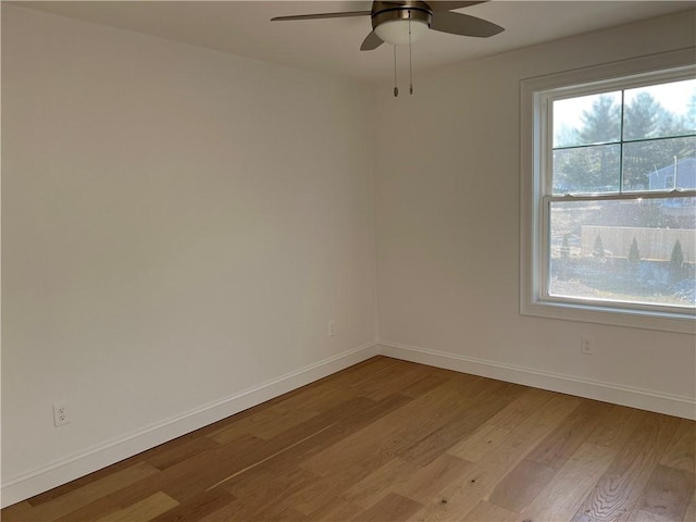 unfurnished room featuring a ceiling fan, light wood-style floors, and baseboards