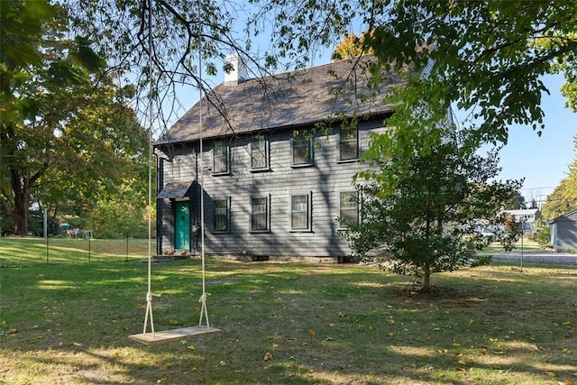 view of side of property featuring a yard and a chimney