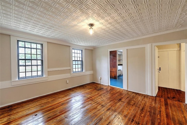 unfurnished bedroom featuring wood-type flooring, an ornate ceiling, and ornamental molding