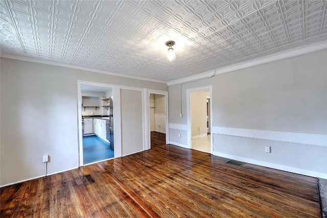 unfurnished room with visible vents, baseboards, ornamental molding, hardwood / wood-style floors, and an ornate ceiling