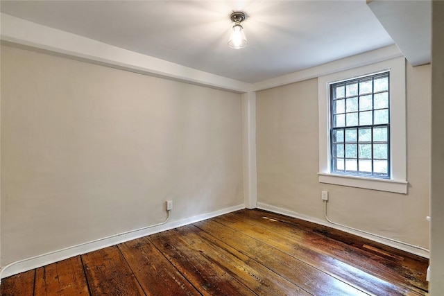 spare room with dark wood finished floors and baseboards