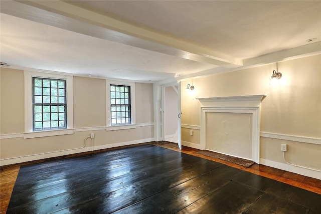 spare room with baseboards and hardwood / wood-style floors