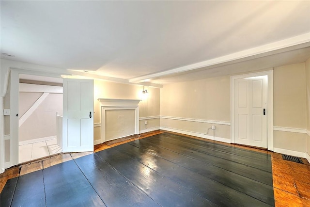 interior space featuring visible vents, baseboards, and hardwood / wood-style floors