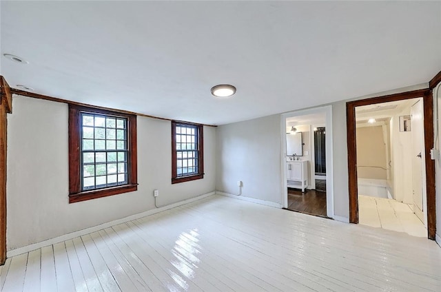 spare room featuring baseboards and hardwood / wood-style floors