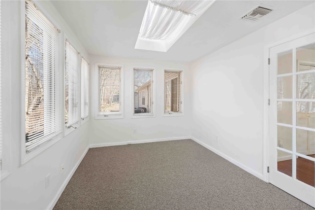 unfurnished sunroom with a skylight and visible vents