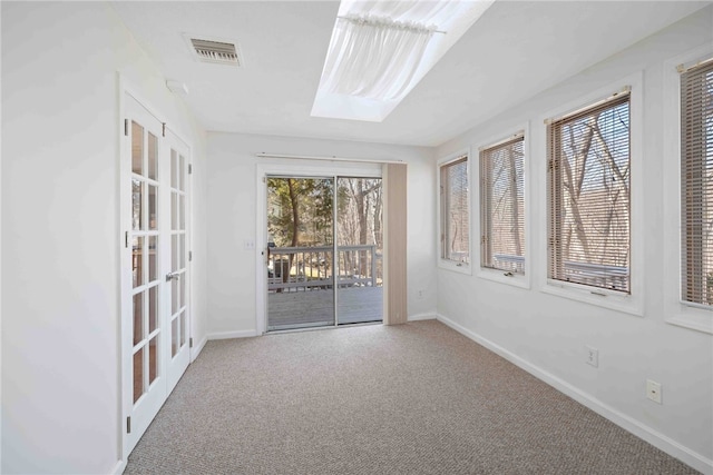 empty room with carpet, visible vents, and baseboards