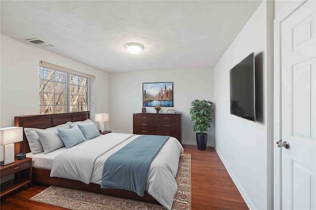 bedroom featuring dark wood-type flooring, visible vents, and baseboards