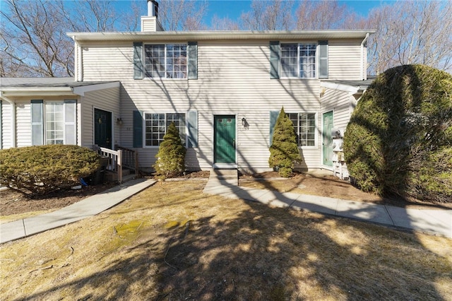 rear view of property featuring a chimney