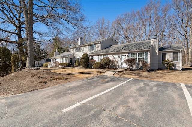 view of front of house featuring uncovered parking and a chimney