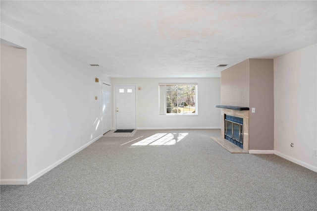 unfurnished living room with light colored carpet, visible vents, baseboards, and a premium fireplace