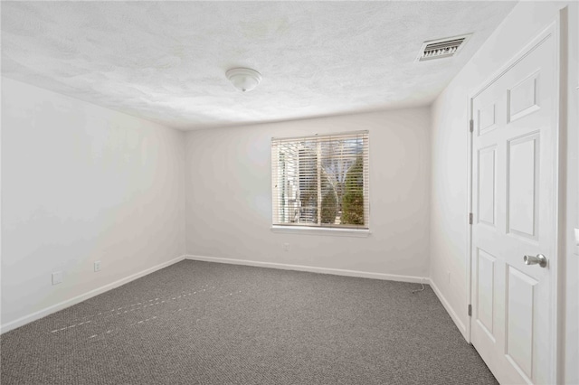 empty room with a textured ceiling, carpet floors, visible vents, and baseboards