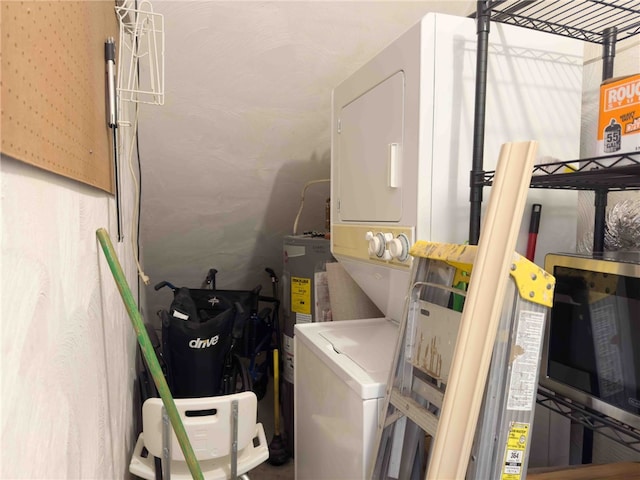 interior space featuring electric water heater, stacked washer and dryer, and laundry area