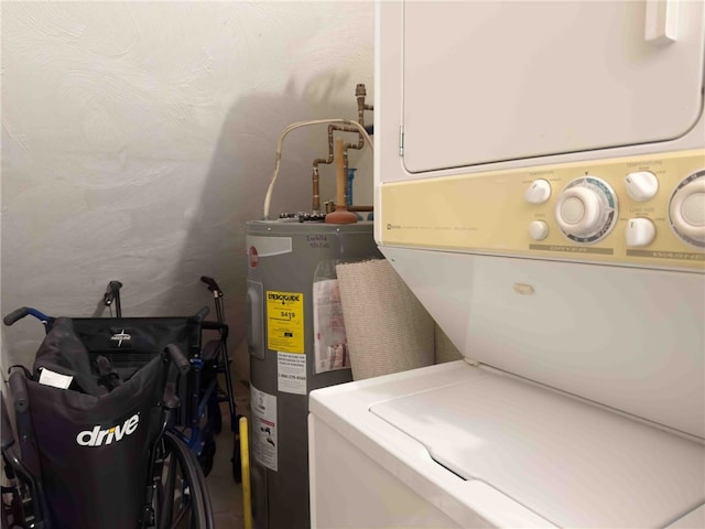 clothes washing area featuring water heater, laundry area, and stacked washer / dryer