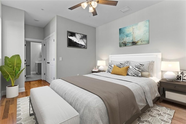 bedroom with wood finished floors, visible vents, and a ceiling fan