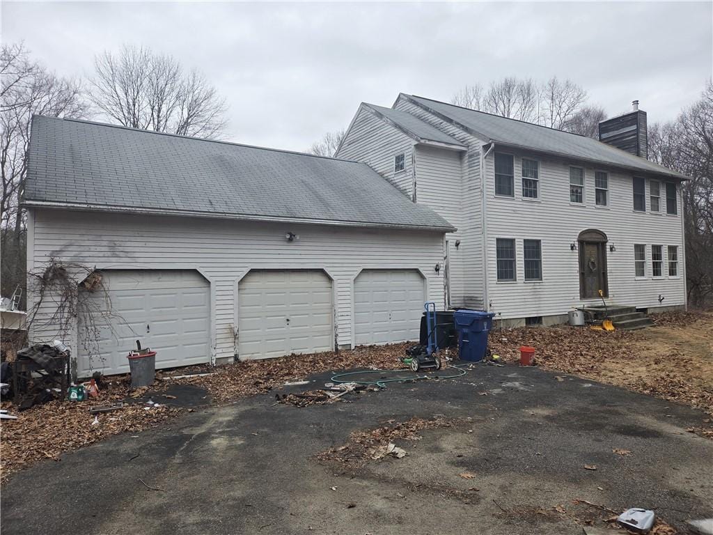 view of front of house with a garage and a chimney