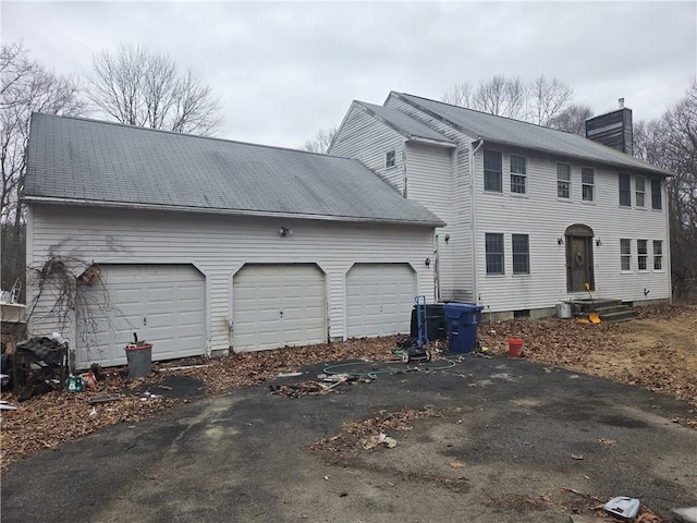 view of front of home with a chimney and a garage