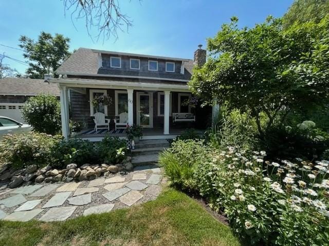 view of front of house featuring covered porch and a chimney