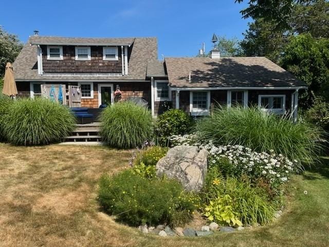 rear view of house featuring a yard