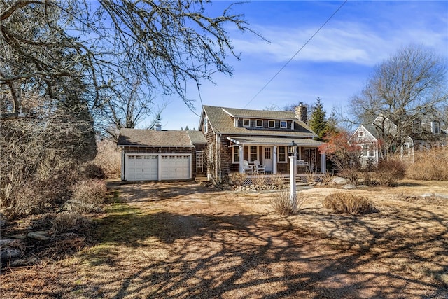 shingle-style home with driveway, a porch, a chimney, and an attached garage