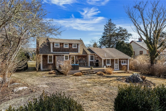 view of front of house featuring a shingled roof and a wooden deck