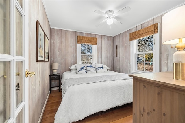 bedroom featuring ornamental molding, wood finished floors, a ceiling fan, and baseboards