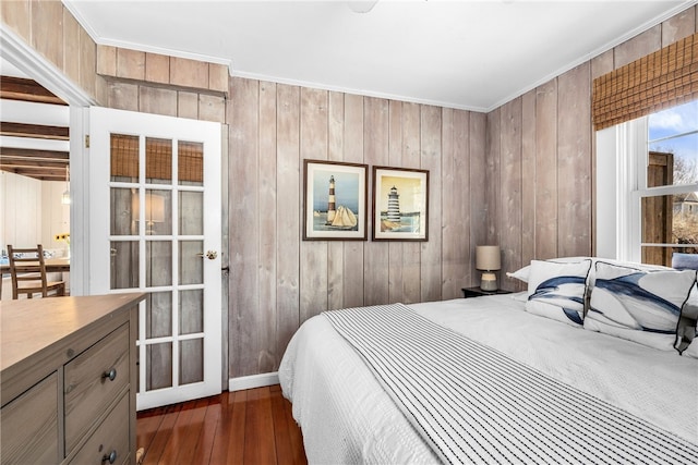 bedroom featuring ornamental molding, dark wood-type flooring, and wood walls