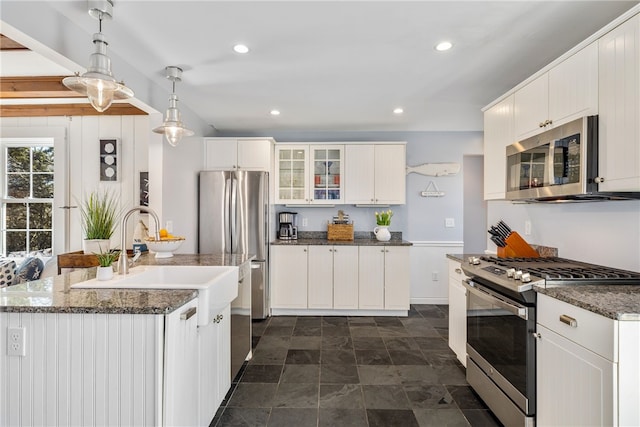 kitchen featuring pendant lighting, recessed lighting, appliances with stainless steel finishes, glass insert cabinets, and white cabinetry