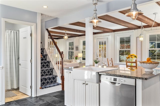 kitchen featuring stainless steel dishwasher, an island with sink, a sink, and beam ceiling