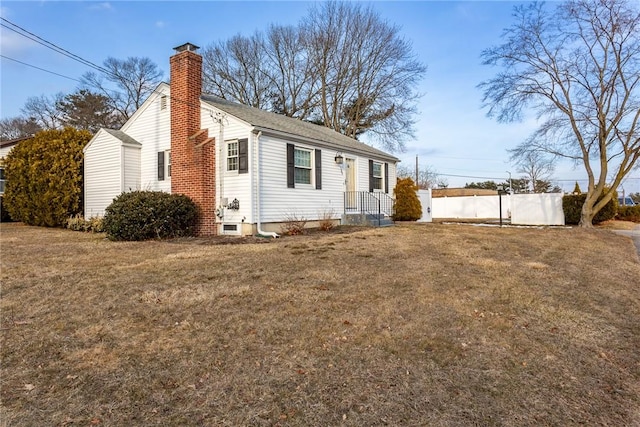 view of front of property featuring a chimney, fence, and a front yard