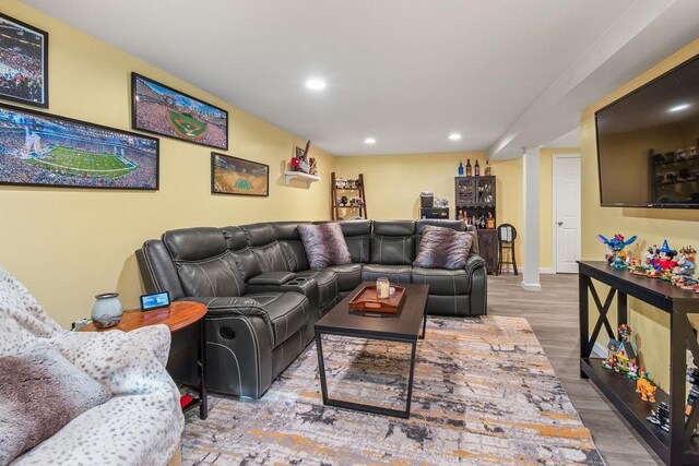 living area featuring baseboards, wood finished floors, and recessed lighting