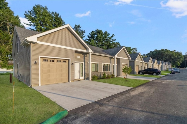 view of front of house with a front lawn, concrete driveway, and an attached garage