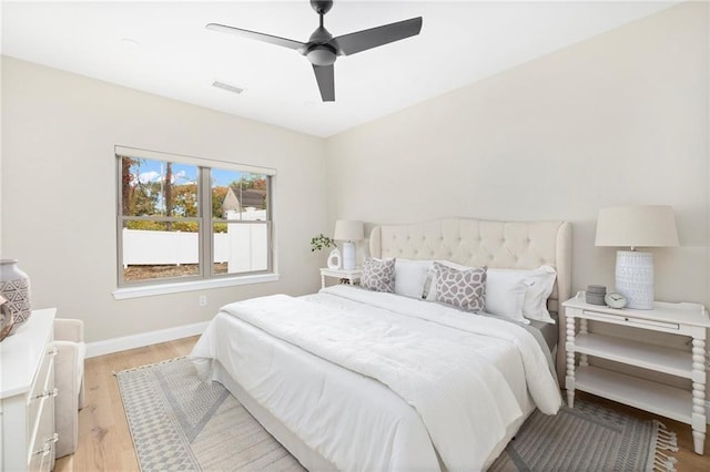 bedroom featuring ceiling fan, light wood-type flooring, visible vents, and baseboards