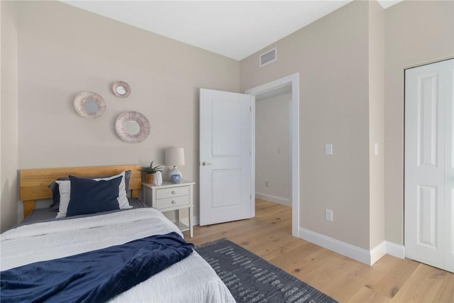 bedroom featuring light wood-type flooring, baseboards, and visible vents