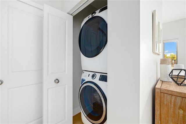 washroom with stacked washer and dryer and laundry area