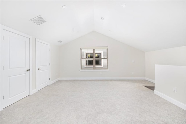 bonus room featuring lofted ceiling, baseboards, visible vents, and light colored carpet