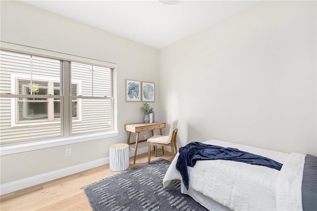 bedroom with baseboards and wood finished floors