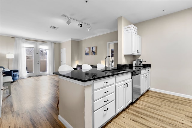 kitchen with visible vents, dishwasher, light wood-style flooring, open floor plan, and a sink